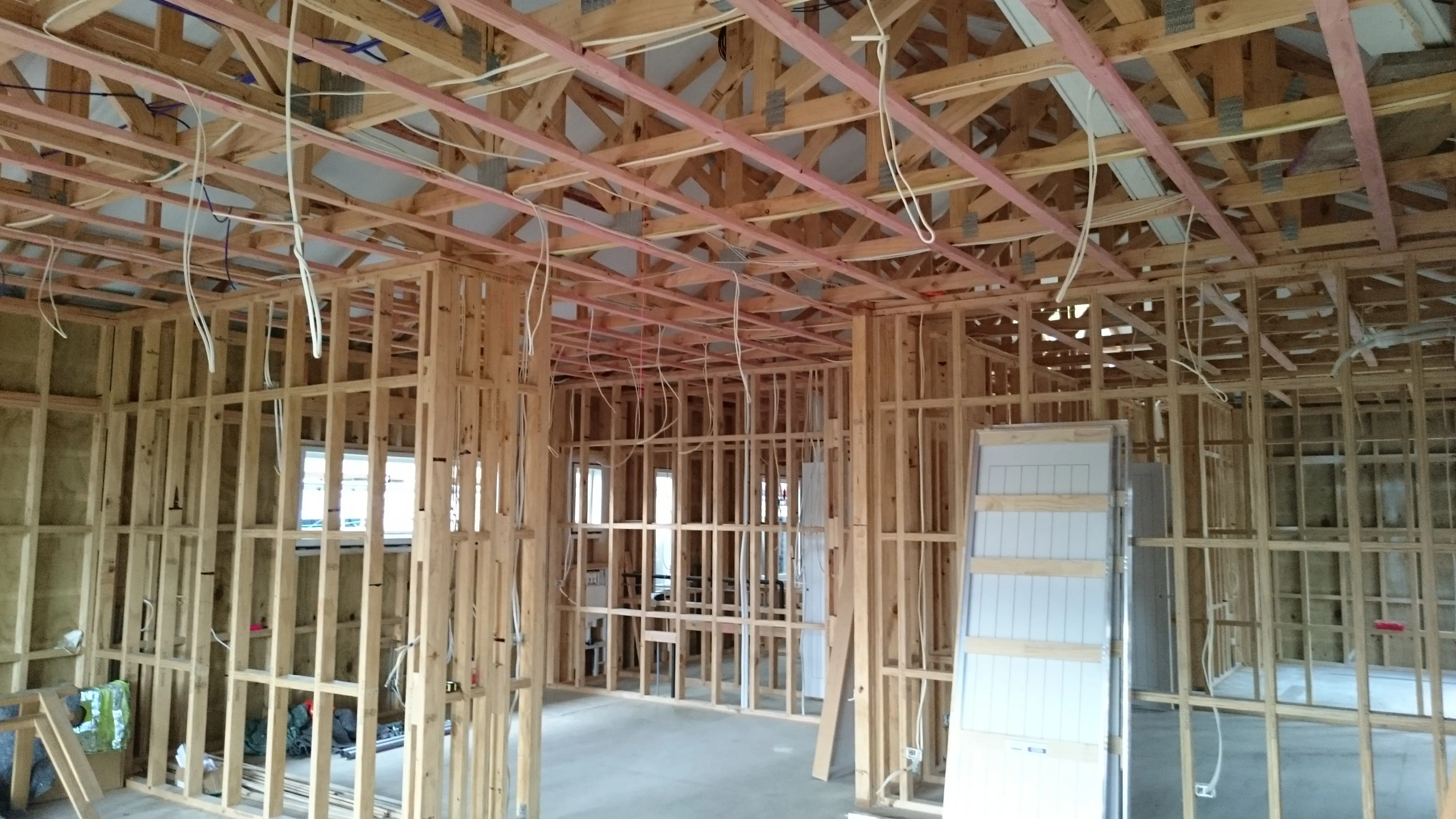Rough in wiring dropped through the framing and roof trusses of a house under construction