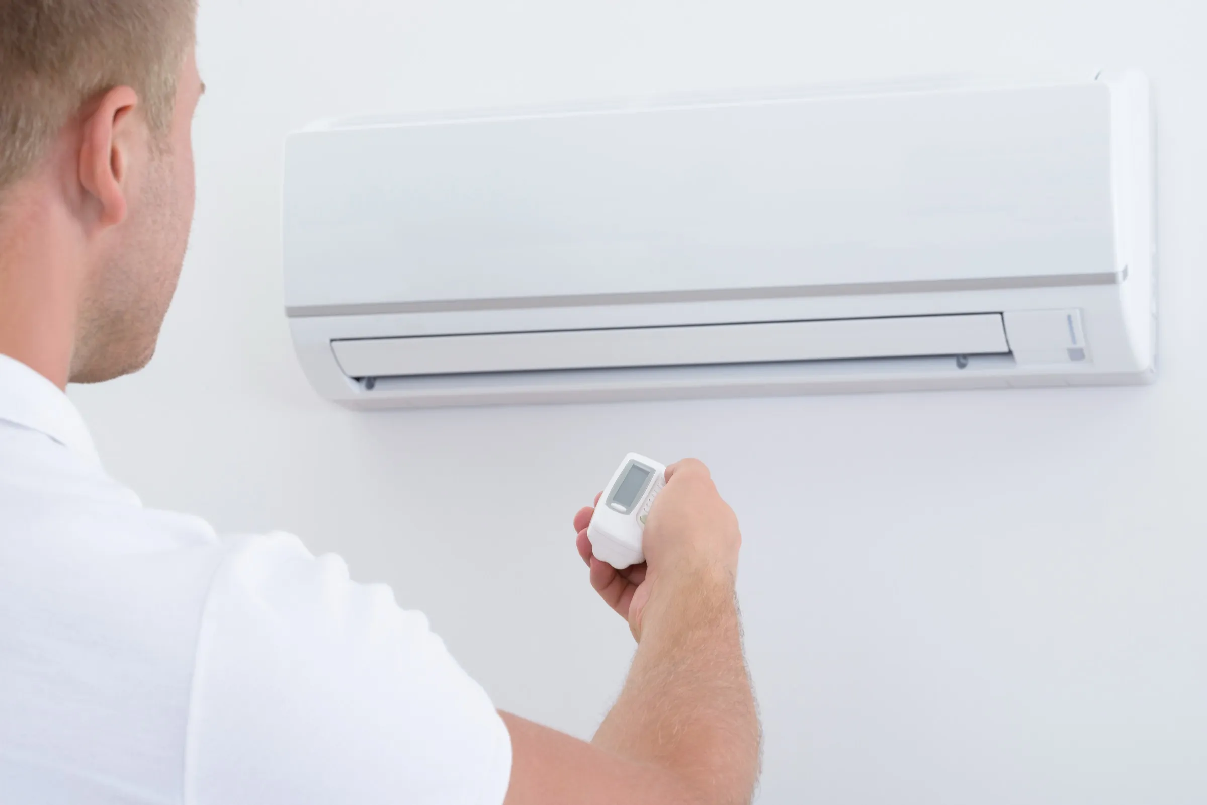 Wall mounted heat pump indoor unit installed high on a lounge wall