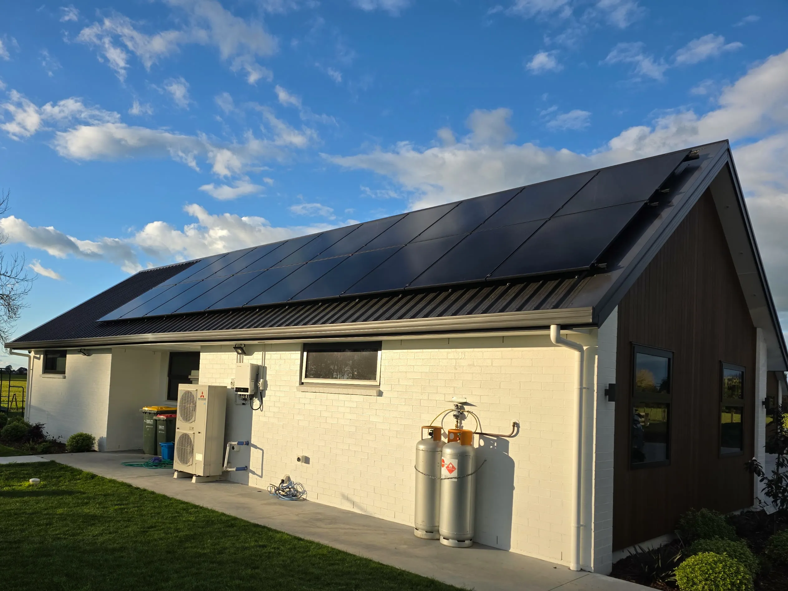 Brick and timber Hamilton house with a heat pump outdoor unit and solar array on the roof